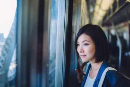 地下鉄の窓から街を眺める女性
