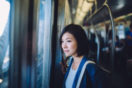 Mulher no metrô olhando para a cidade
