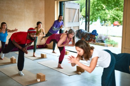 A photograph of a multiracial group practicing yoga in a class