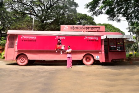 woman poses infront of a TI Bus in Pune India