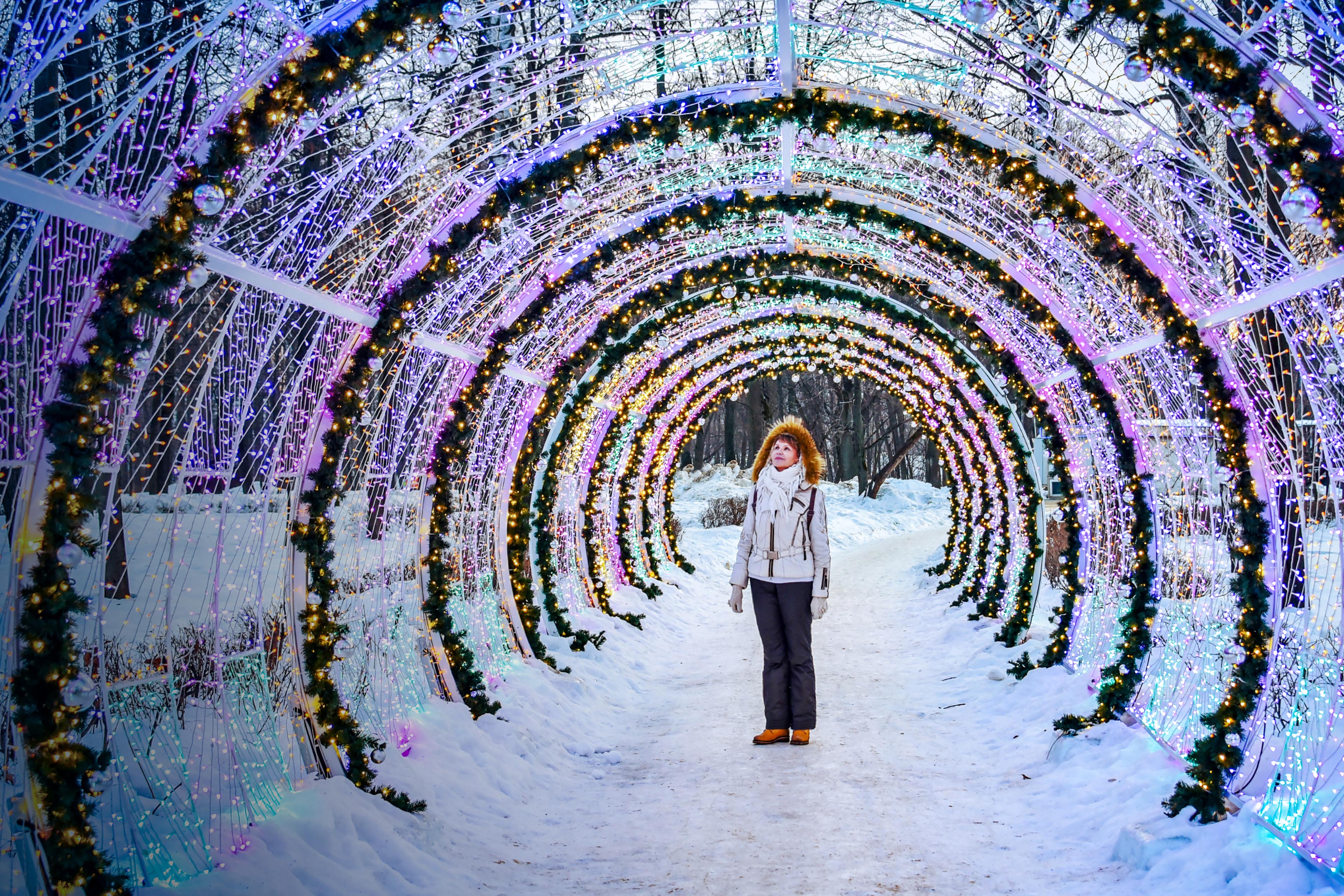 Woman is standing under the christmas lights park
