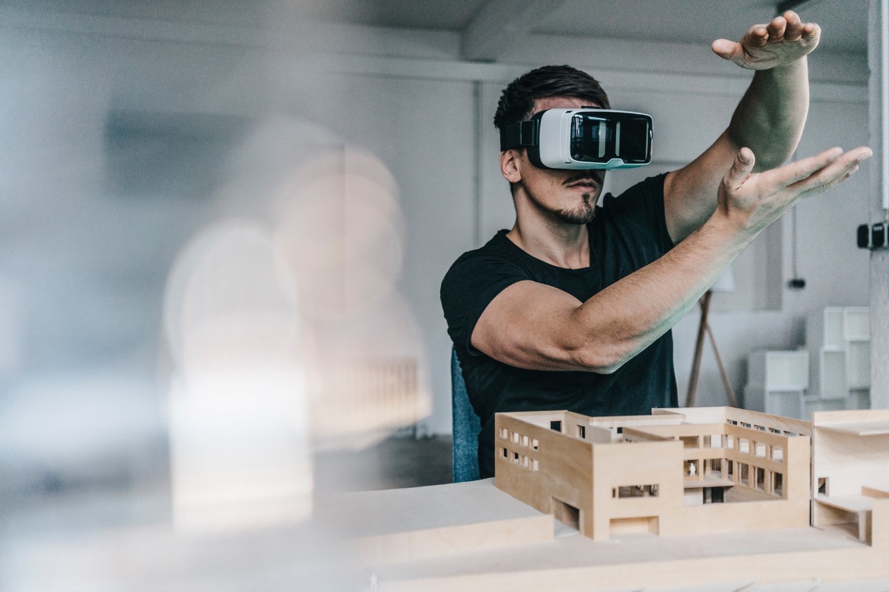 Homem com modelo de arquitetura e óculos VR