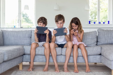 children couch using tablets smartphones