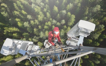Electrician climbing up telephone mast structure