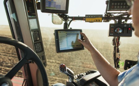 Farmer using touchscreen in tractor