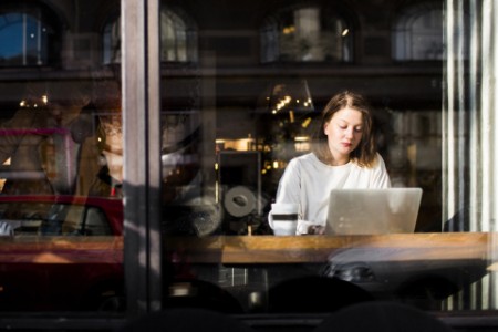 Woman laptop cafe through glass window