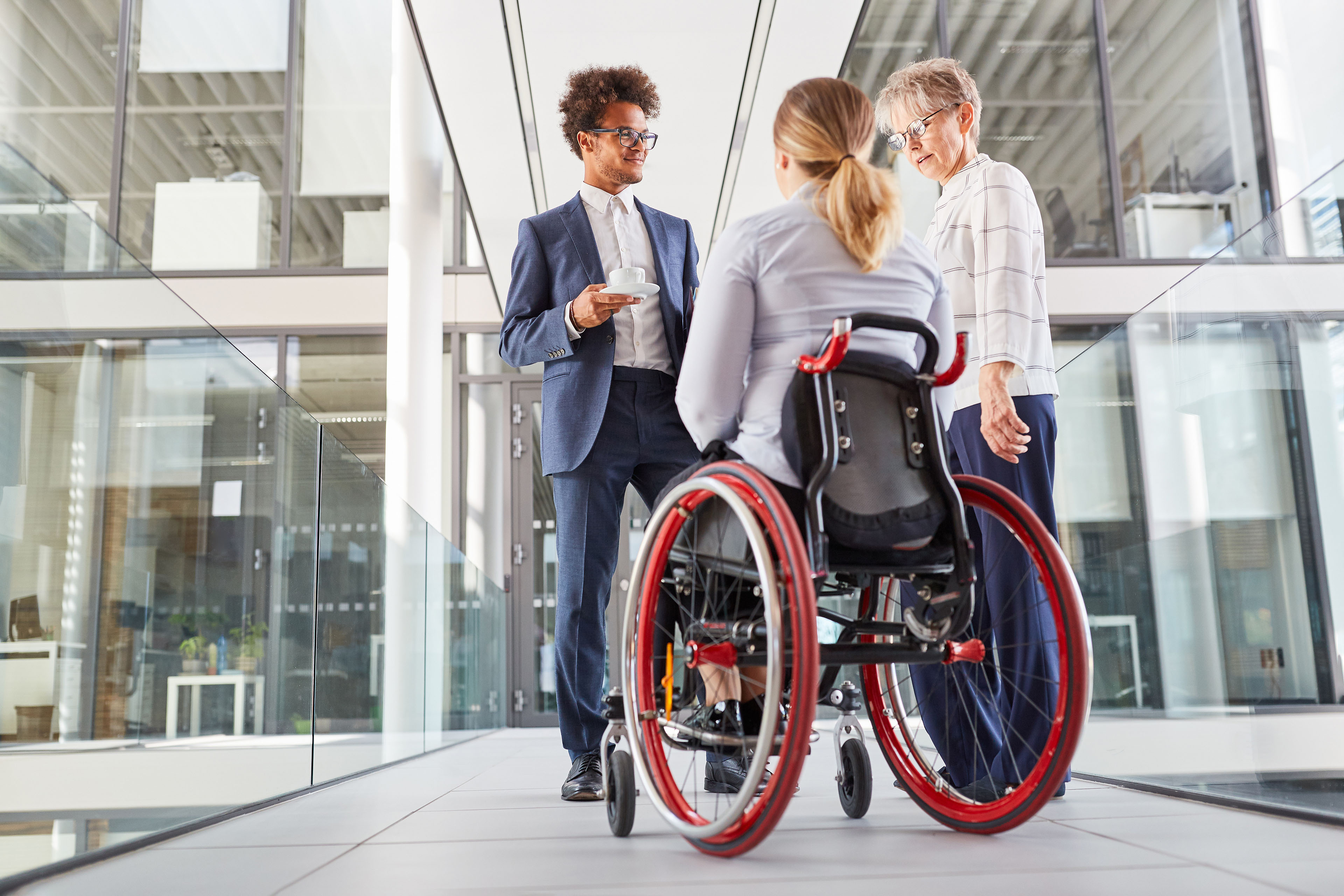 Businesswoman in a wheelchair talking to colleague