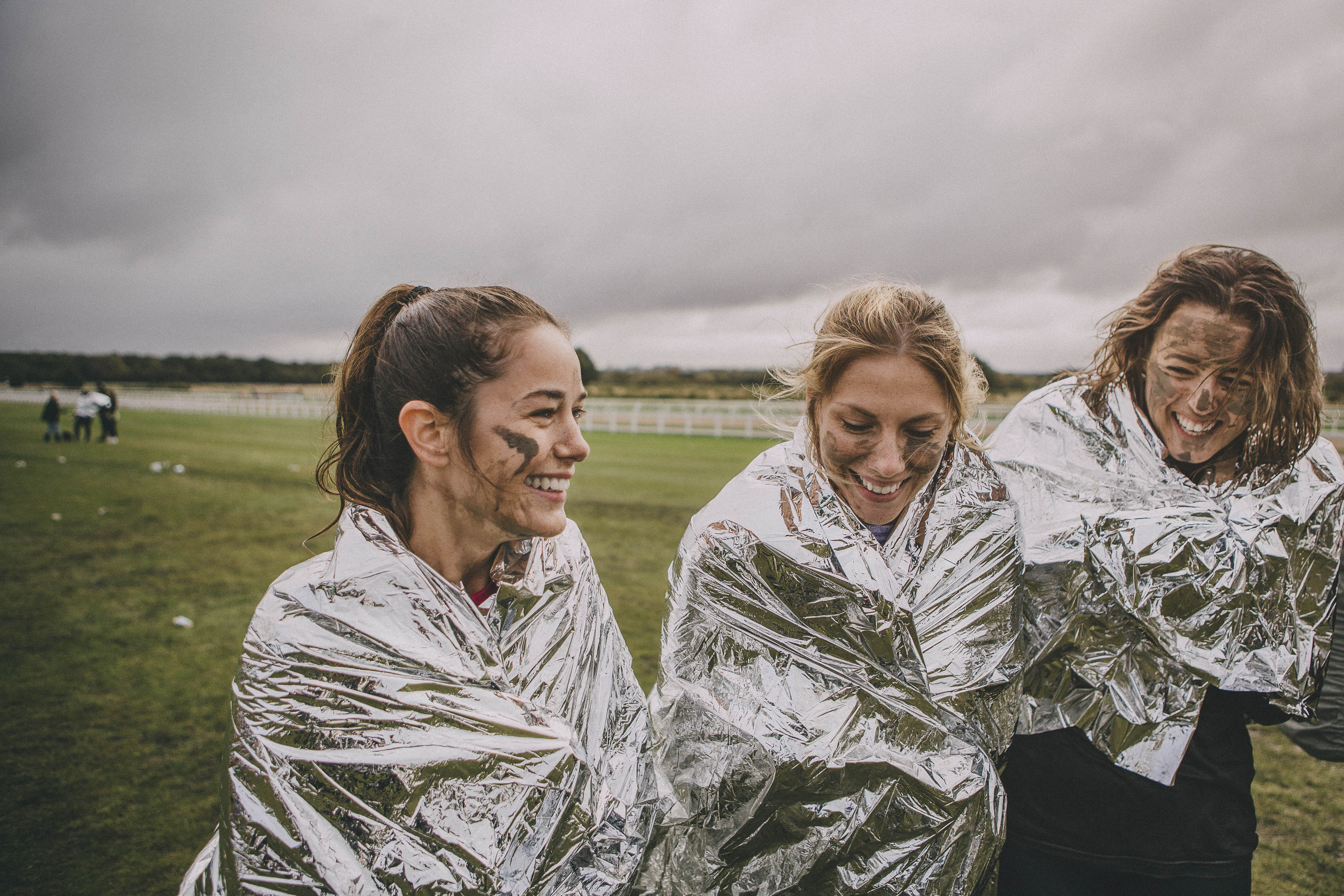 Woman keeping warm with thermal foil blankets after race
