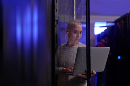 Shot of a young female engineer working in a server room