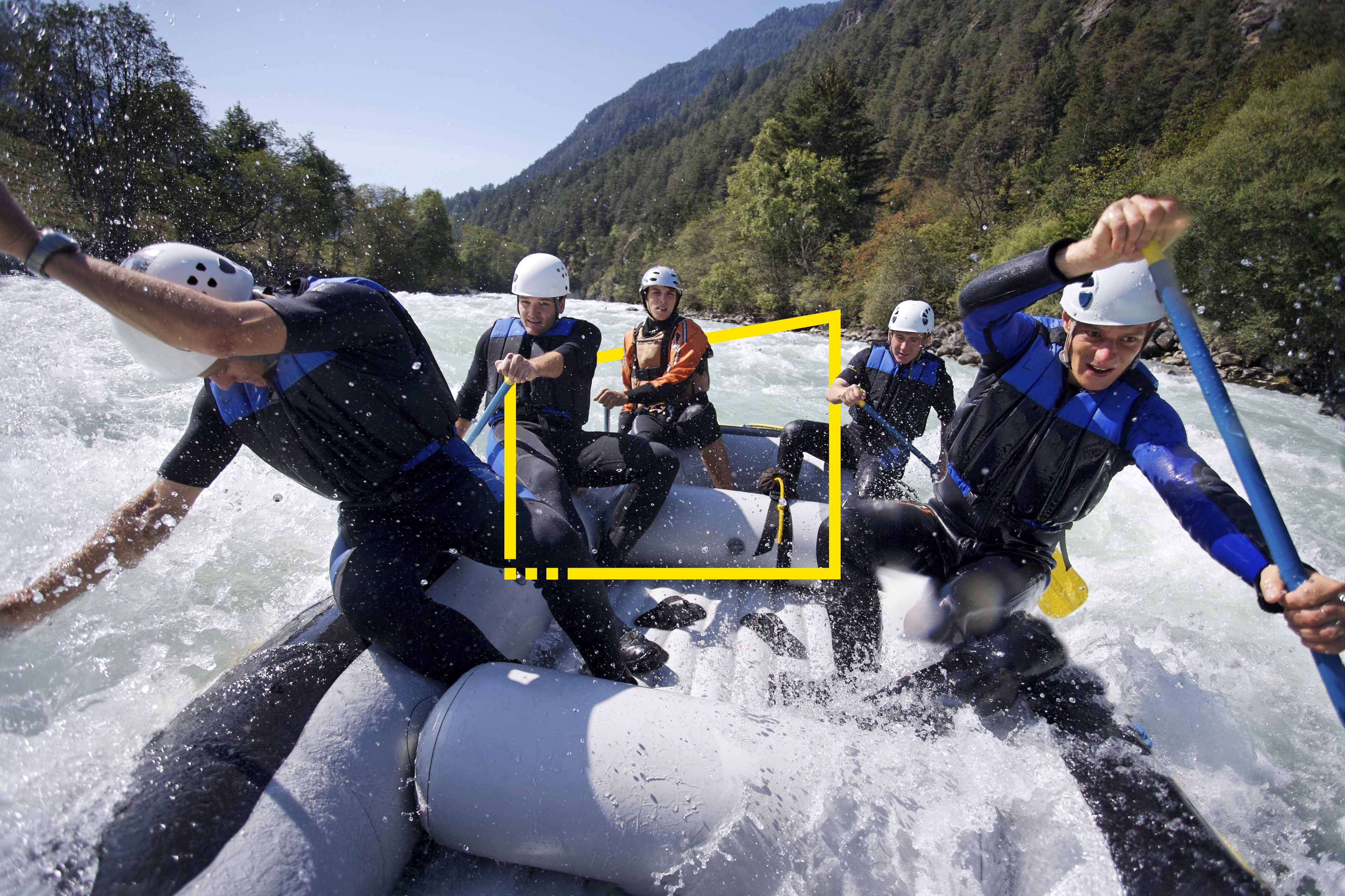 Group of men whitewater rafting 