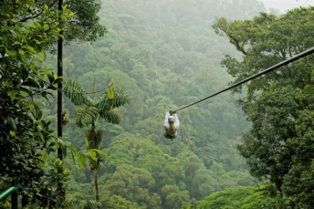 A person zip lining above a forest in costa rica