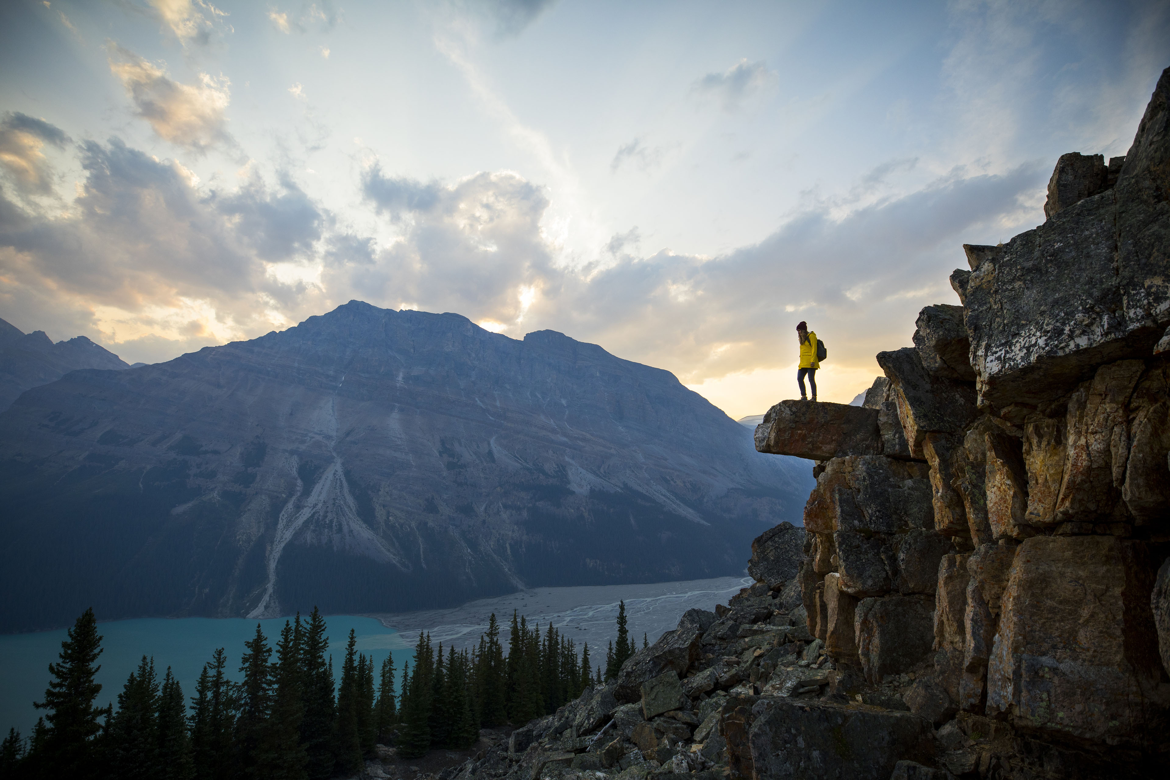 A young woman standing on a rock overlooking Peyto Lake.