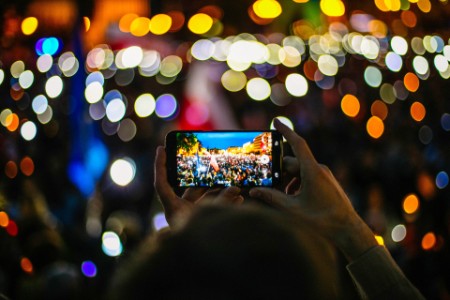 
            Protesta de la multitud fotografía en la noche del teléfono móvil
        