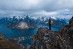 Hiker with backpack enjoying sunset landscape in Lofoten Norway