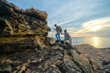 Young Asian couple climbing up the cliff
