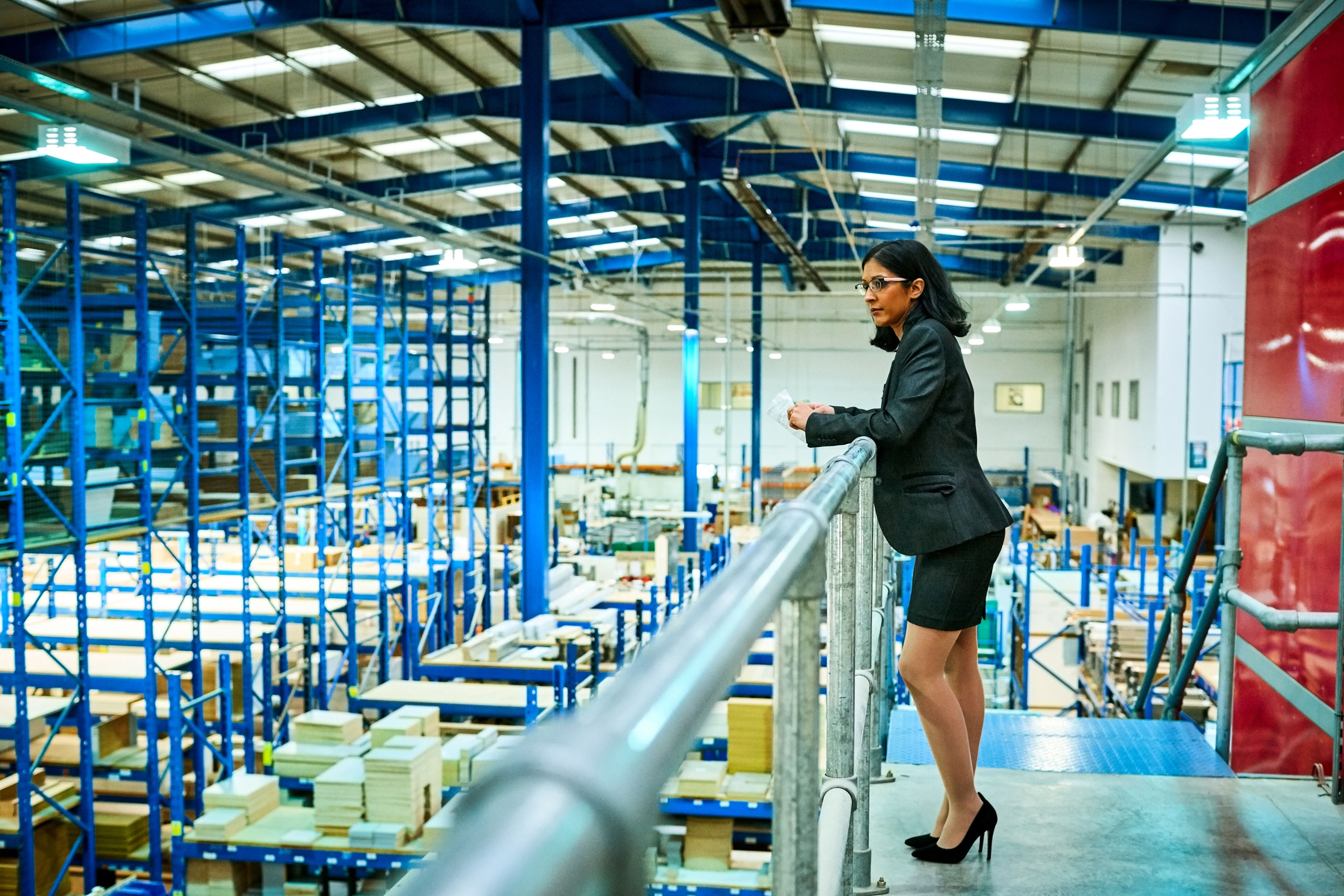 Clients: Business woman standing factory balcony