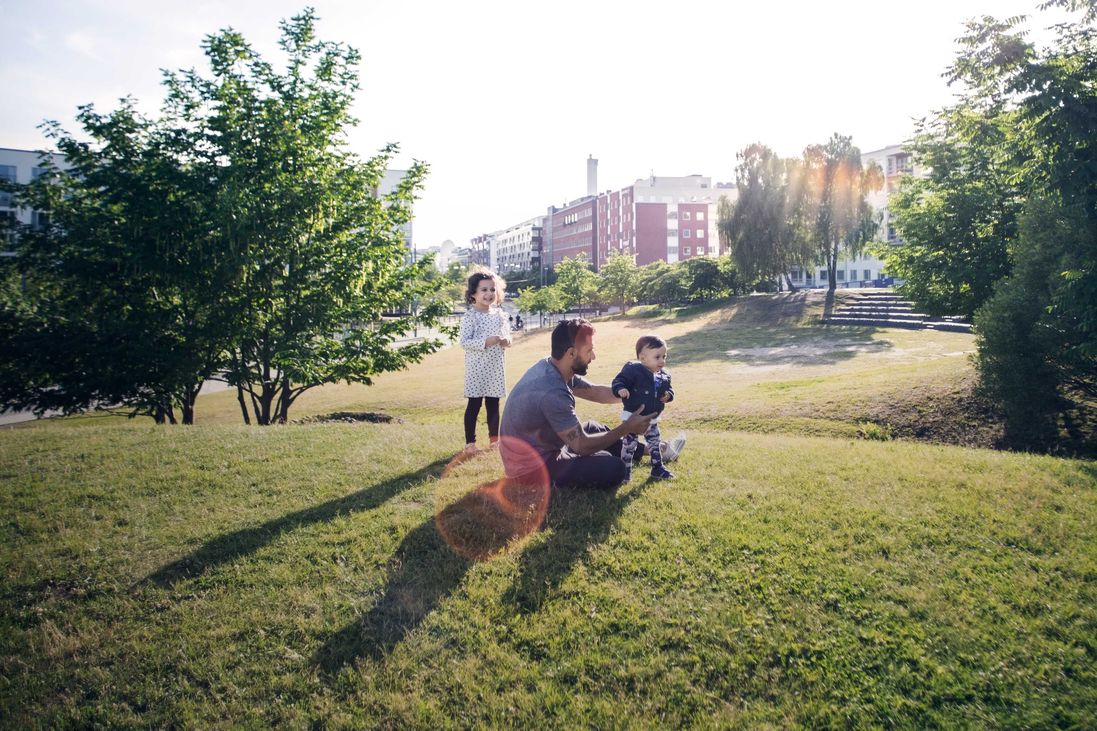 Father playing with children on grassy field