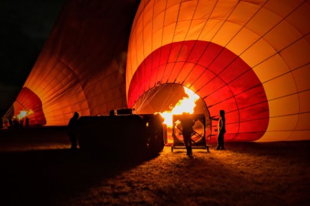 view of hot air balloons being inflated at night