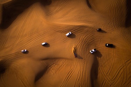 砂漠の砂上でレースをする車両の空撮