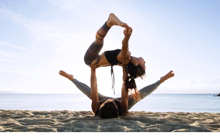 Twee mensen balanceren in een yogahouding