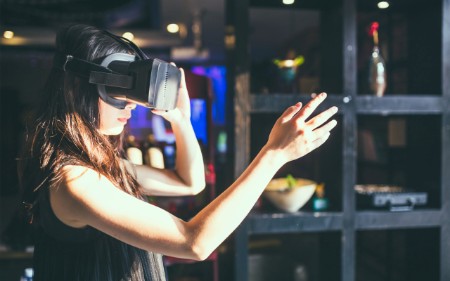 Woman interacting with video through VR goggles 