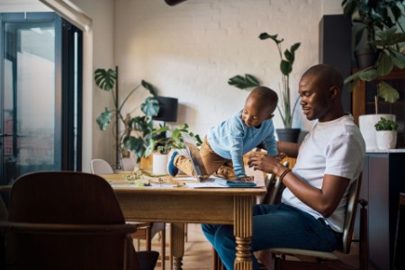 Black man and son in their home together to work on finance