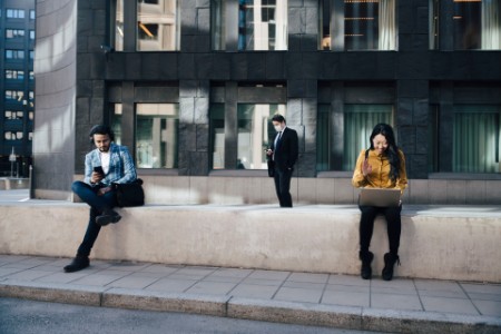 Personas de negocios conservando distanciamiento social trabajando al aire libre