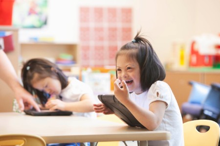 Girl playing on tablet in classroom