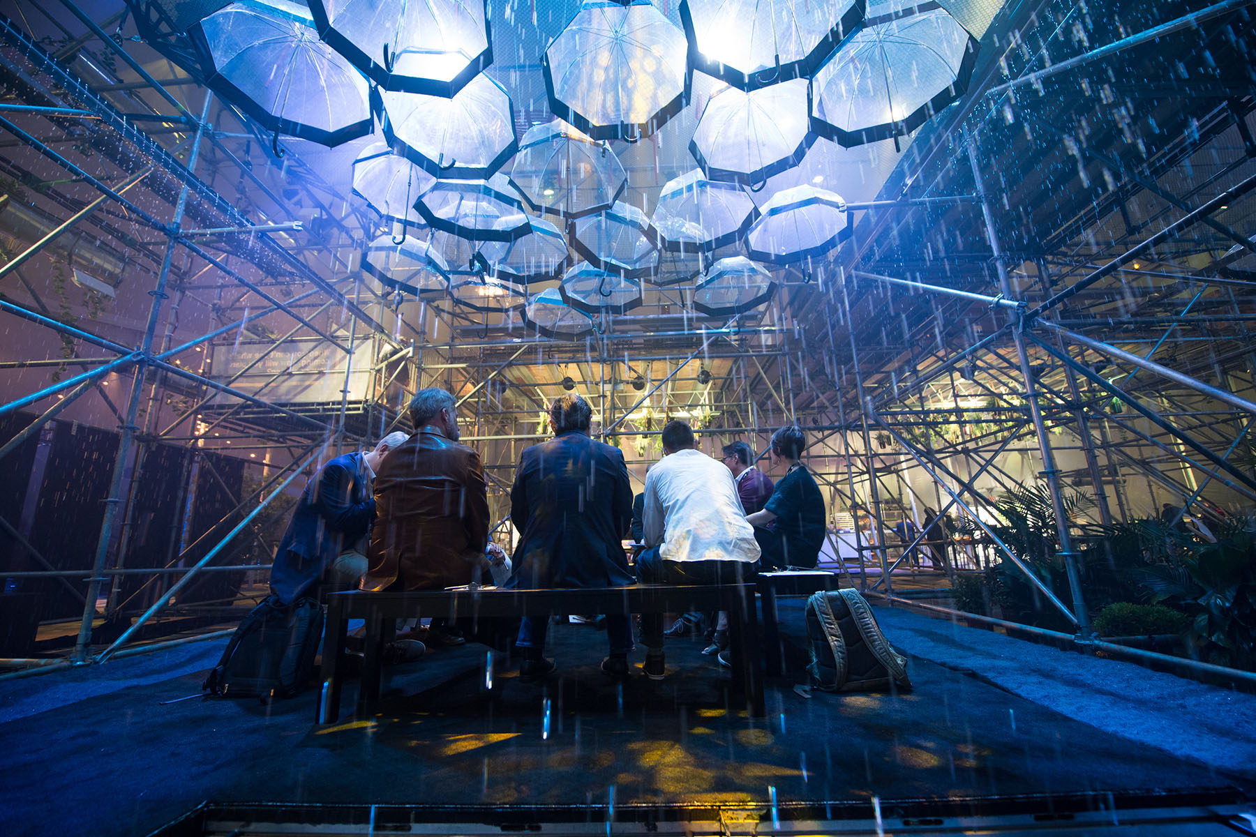 People sit under umbreallas at Innovation realized