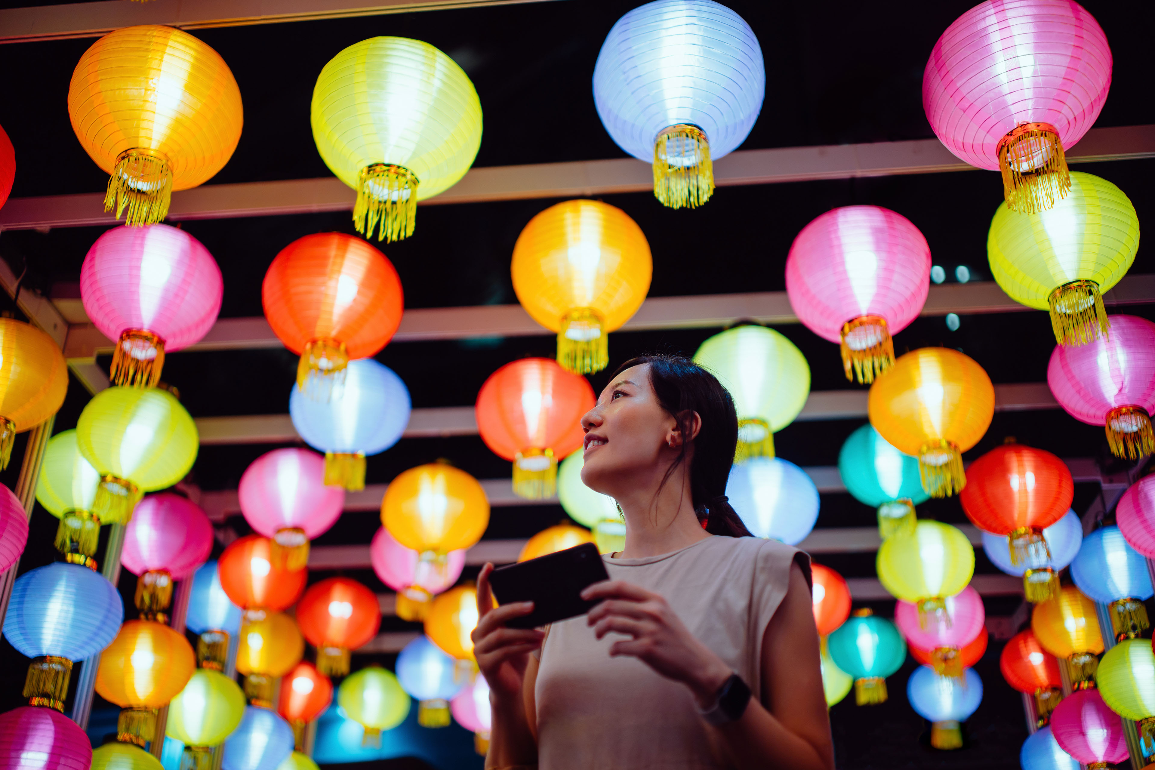 Mujer tomando fotos de coloridas linternas chinas tradicionales