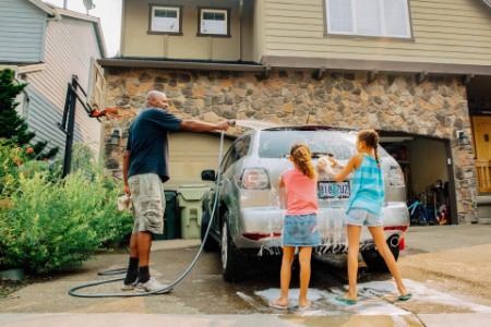 Father and daughters washing car