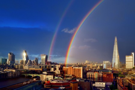 London cityscape after rain with double rainbow in dark sky
