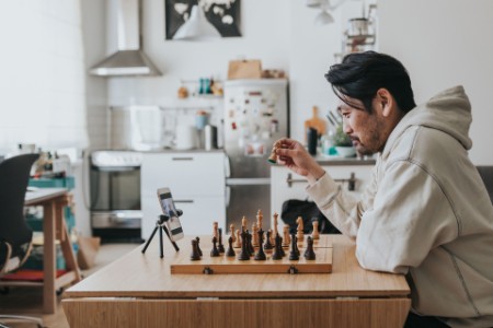 
            Homme jouant aux échecs avec un partenaire en ligne
        