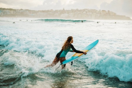 Woman with a surfing board in the sea