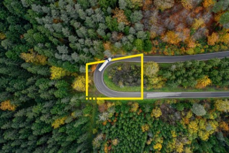 Aerial view of winding road through a forest in autumn in germany