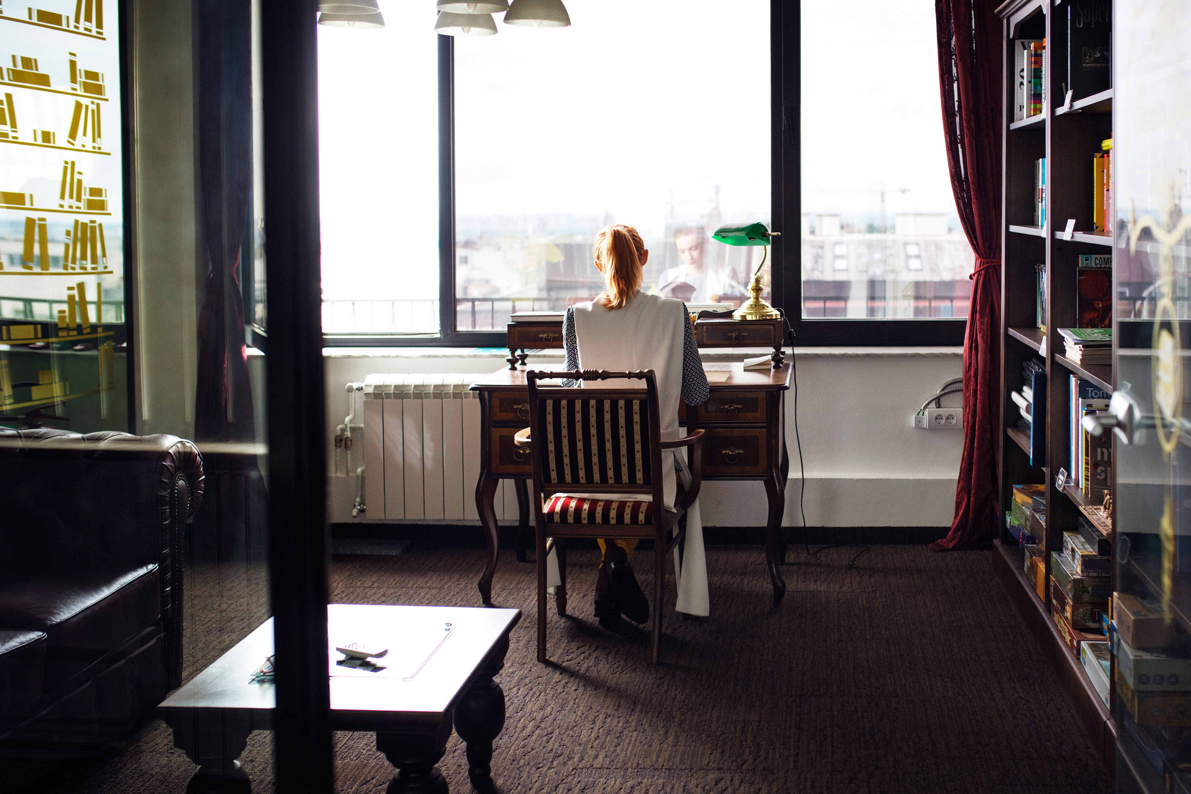 woman sits at a desk in her apartment