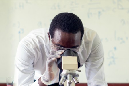 African scientist using microscopes in laboratory