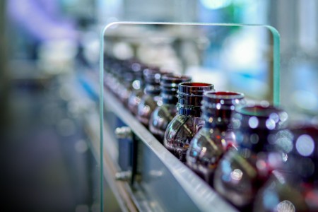 Close-up of brown glass medicine bottles at production line