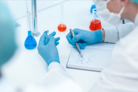 Scientist writing down a chemical formula