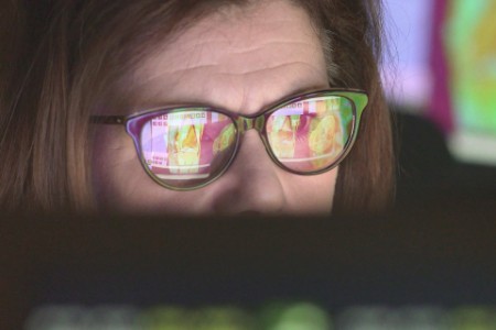 Ældre kvinde ser nøje på computerskærme. Skærmbillederne viser MR-scanninger.