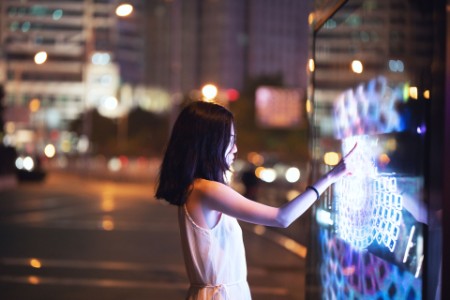 Young woman using touch screen on the street