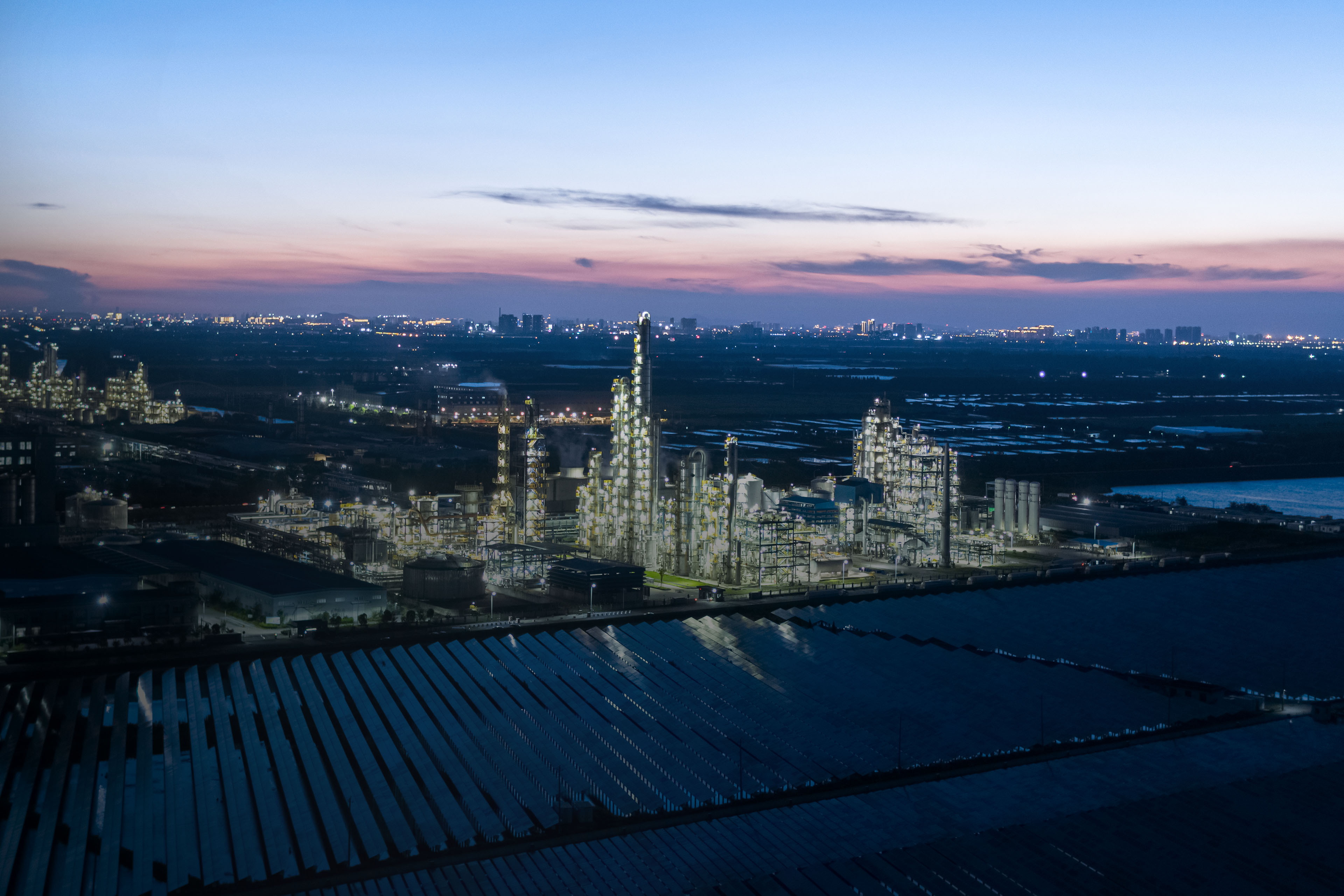 Chemical plant with solar power station at night