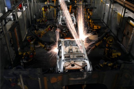 Robotic arms weld a vehicle chassis