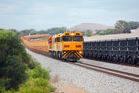 Loaded hematite iron ore train passing empty magnetite wagons