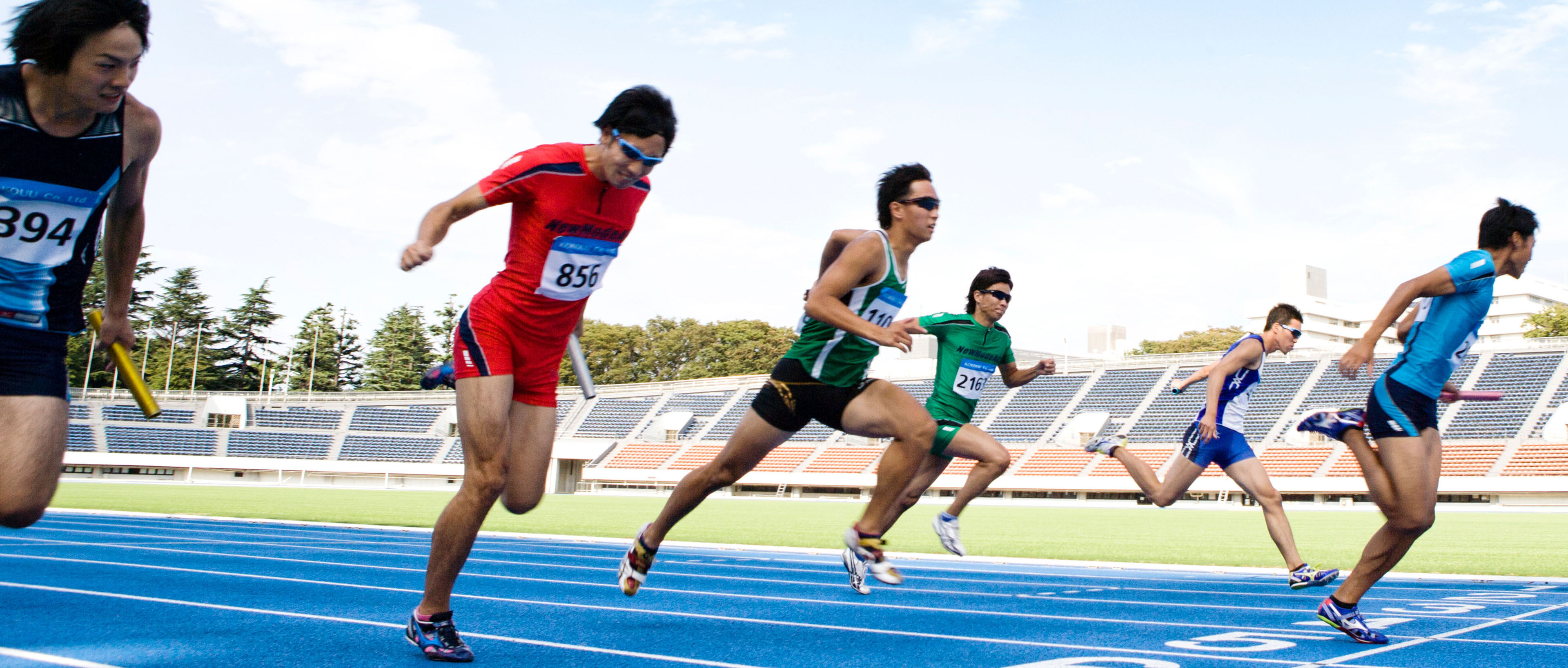 Deportistas masculinos corriendo hacia la línea de meta