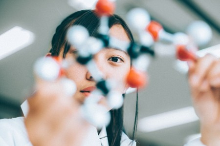 Estudante com modelo de moléculas num Laboratório de Química