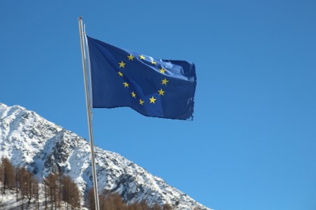 European Union flag flying in front of a snowcapped mountain
