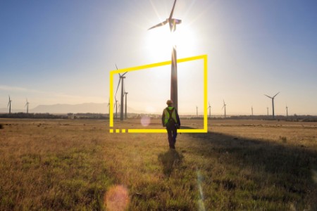Engineer walking on a wind farm at sunset