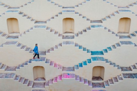 Young woman climbs staircase maze