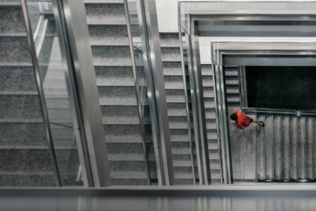Man in red shirt walking up the staircase